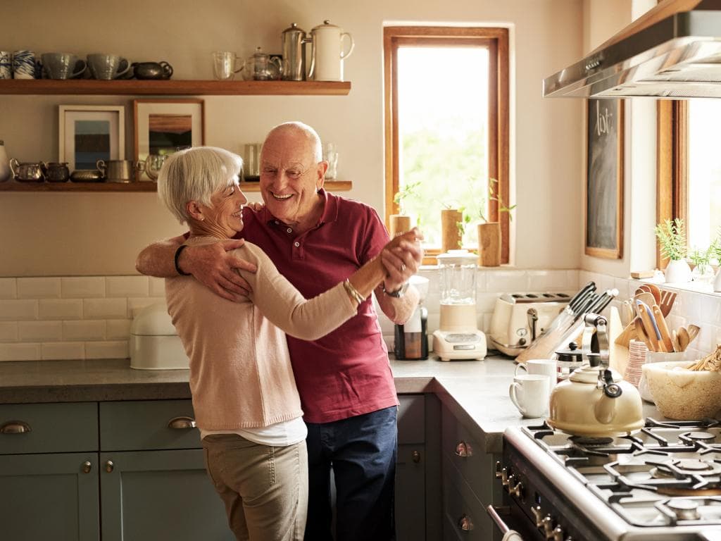 Elderly people dancing in kitchen L